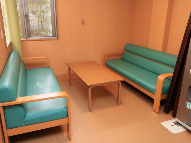 温もり感じる休憩室の様子 休憩コーナー 柔らかい光が差し込む休憩室では、ゆったりとしたソファで一息つくことができます。木目調の家具が落ち着いた雰囲気を演出しています。