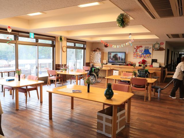 共有スペースの明るい風景 食堂 ゆとりのある食堂で、掃除の行き届いたテーブルや椅子が整然と配置され、来訪者を温かく迎えます。天井の高い開放的な空間は、日常の憩いの場を提供しています。
