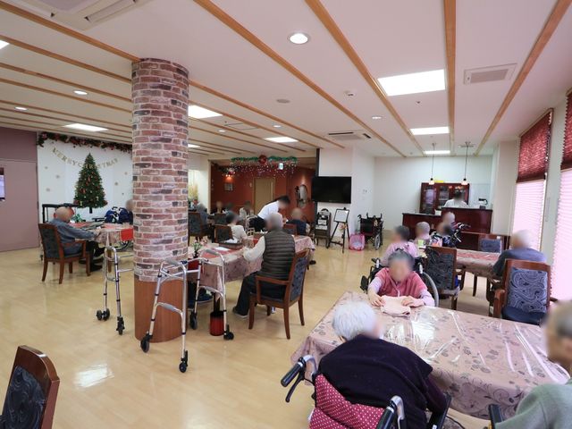 広々とした共用ダイニング ダイニング 季節の飾り付けが施された温かみのあるダイニングで、利用者の方々が食事や憩いの時を過ごされています。ゆったりとした席間で車椅子の方も快適に時間をお過ごしいただける設計です。