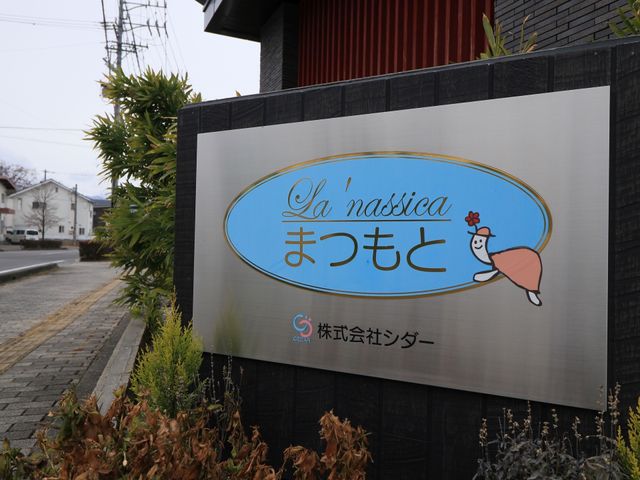 看板と花と植物 看板 温かみのあるデザインの看板が、訪れる方を明るく迎えています。職場としての環境が気になる方にも、親しみやすい雰囲気が感じられるでしょう。
