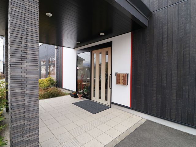 入口の近代的デザイン エントランス 清潔感があふれるエントランスです。手入れが行き届いた植栽が迎えてくれ、訪れる方に安心感を提供します。