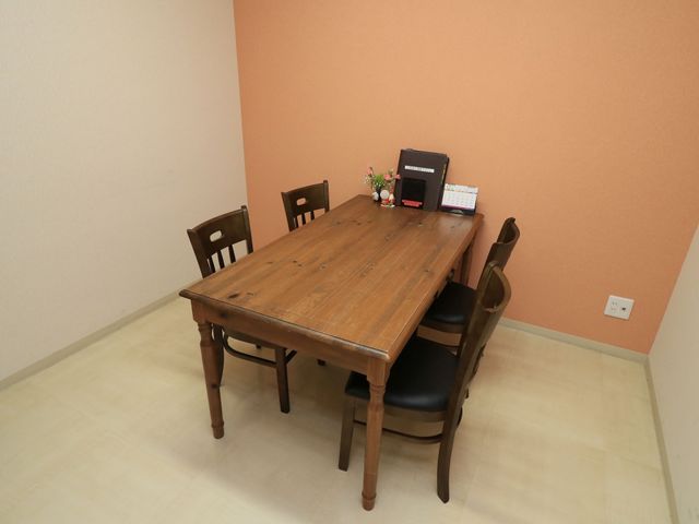 温かみのある木製テーブル 相談室 ゆったりとした時間を過ごせる、木製テーブルの休憩スペースです。周りは落ち着いた色合いで、リラックスした雰囲気が漂います。