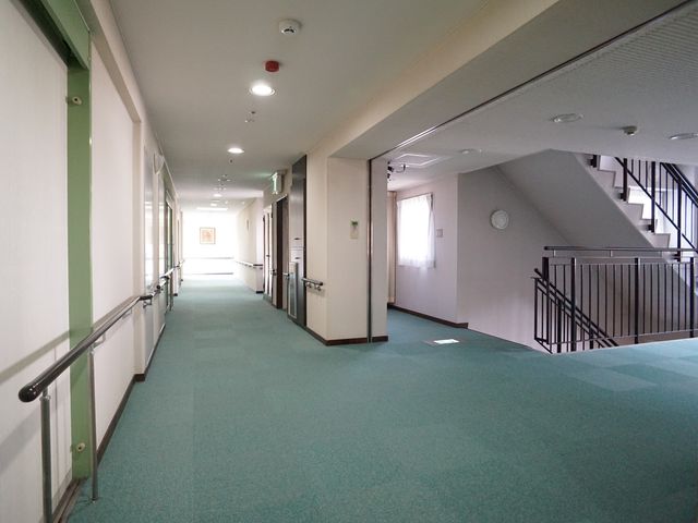 清潔な廊下と手すり 廊下 手すりが設置された明るい廊下は、安全に移動するために工夫されています。ゆったりとした空間で快適な勤務環境が整っています。