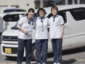 送迎車の前のスタッフ  