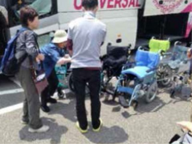 車いすの乗降支援 イベント 職員が車いすの方を優しく支え、バスへの乗降をサポートしています。利用者様の安全と快適な移動を第一に考えたケアが行われています。