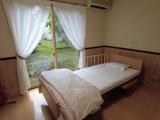 明るい居室 居室 大きな窓から自然光が差し込む、シンプルで快適な空間です。家具も整然と配置されています。