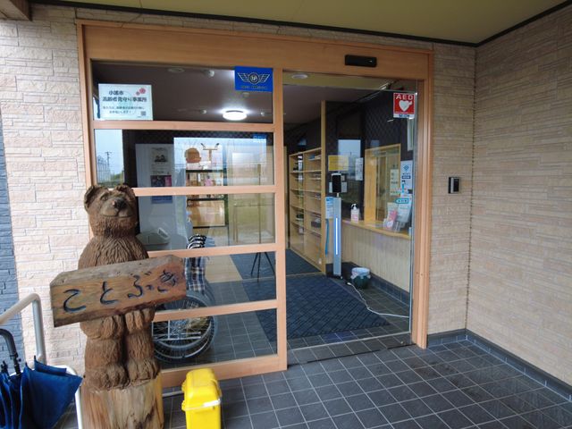 落ち着いたエントランス エントランス 入る際に温かい木彫りのクマが出迎えています。シンプルで安心感のある入口です。