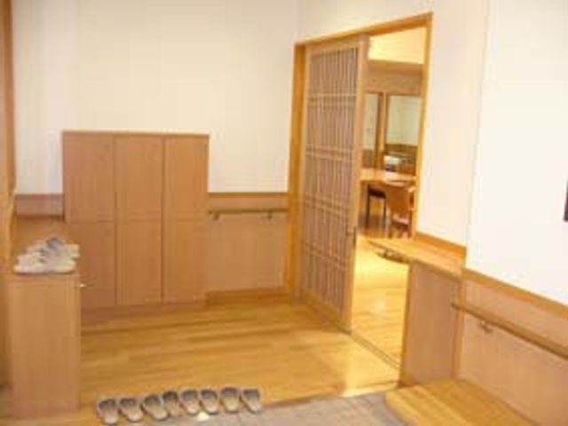 木製の扉とスリッパがある部屋の入口 エントランス 木の温もりを感じるエントランスです。居室までの移動もスムーズに行えます。
