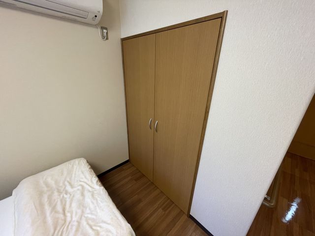 ゆとりの居室 居室 床にはカーペットが敷かれ、シンプルなベッドとエアコンが設置された落ち着いた空間です。