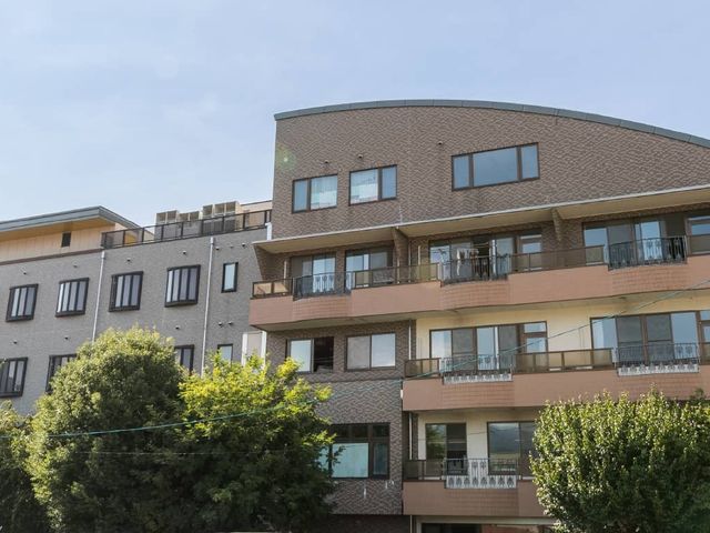 三階建ての施設外観 外観 緑に囲まれた三階建ての建物です。日差しを浴びて、明るい雰囲気を感じることができます。