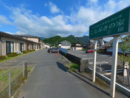 青空と駐車場の外観