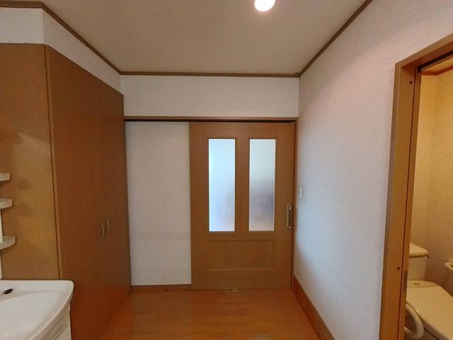 扉と洗面台の居室 居室 落ち着く木目調の扉で仕切られた空間と、手軽に使える洗面台が備わった部屋です。