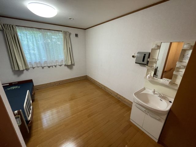 明るい居室 居室 自然光が差し込む広々とした空間は、明るさと快適さを提供します。洗面台も完備されています。