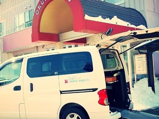 送迎車が停まる入口外観  