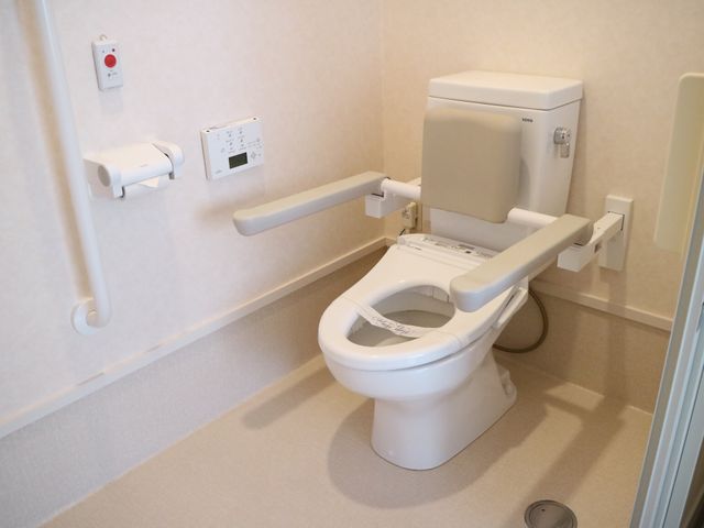 バリアフリートイレ設備 トイレ 手すり付きで安全性を考慮したトイレです。利用者の自立を支援し、快適さへの配慮が感じられます。