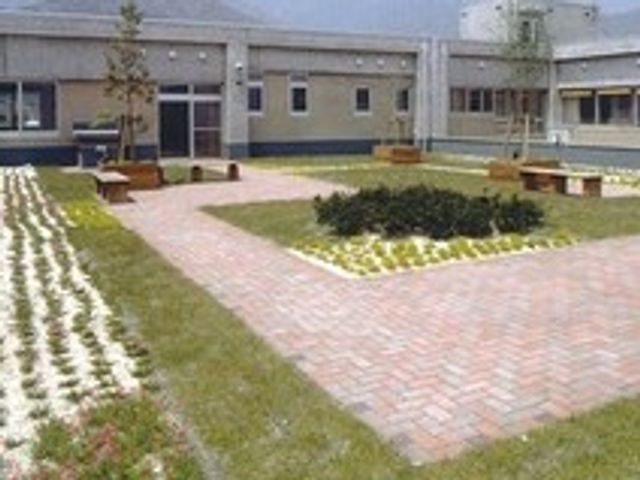 開放的な庭園 庭 敷地を囲む通路とベンチがあり、休憩や散歩にぴったりです。緑豊かな空間が心を和ませます。