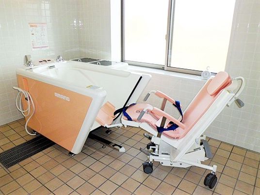 白とピンクの機械浴が置かれた部屋。介護度が高い人も入浴できる設備。