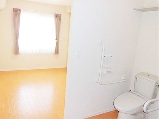 トイレ付きの居室。トイレにはエル字型の手すりと可動式の手すりが付いている。
