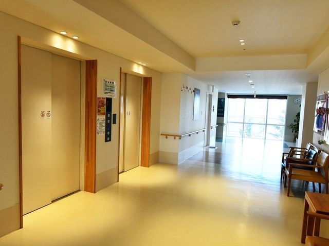 自然光が入る廊下 廊下 広々とした廊下には椅子が設置され、自然光が差し込む明るい空間です。