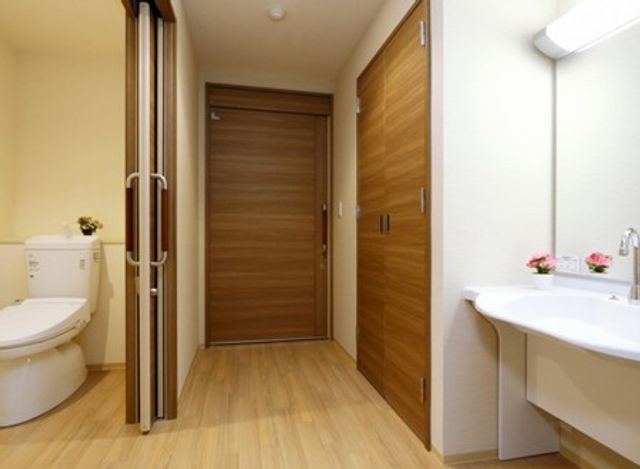 明るいトイレと洗面台 トイレ 広々とした空間に、明るい照明が快適なトイレと洗面台のエリアです。実用的な配置になっています。