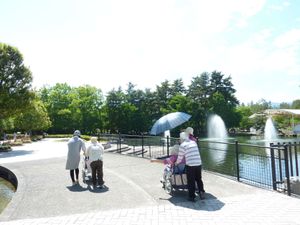 散歩する人々と噴水の庭