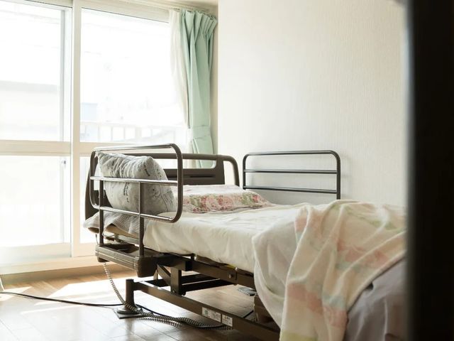 明るい居室のベッド 居室   大きな窓から自然光が入る、落ち着いた雰囲気の居室です。電動ベッドが置かれ、休息しやすい空間になっています。