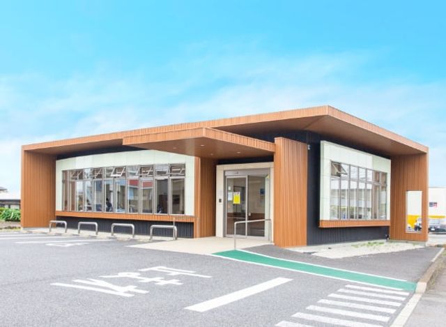 入り口のある建物外観 外観 広々とした駐車場がある建物です。明るいデザインが印象的なエントランスが特徴です。