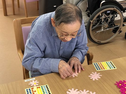 紳士がカラフルな花並べを楽しむ様子