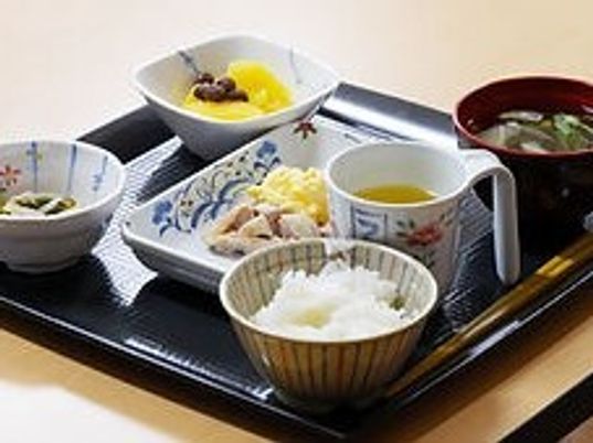 白いご飯やみそ汁、肉料理のようなものや野菜の小鉢などが並んだトレー。
