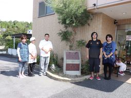 スタッフが立つ施設前