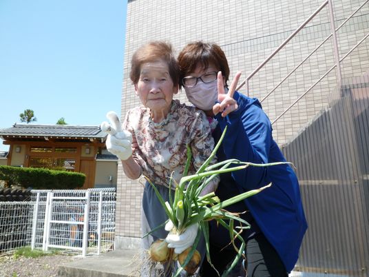 笑顔でトマトを持つ人々