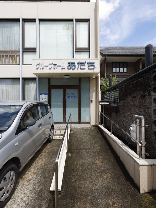 施設の写真 駐車場とスロープが設置してある介護施設の外観