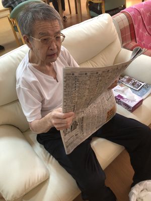 新聞を読む高齢男性