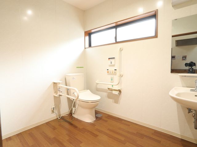 バリアフリー対応の浴室 トイレ 手すり付きのトイレと洗面台を備えた清潔感のあふれる空間です。身体の不自由な方も安心してご利用いただけます。