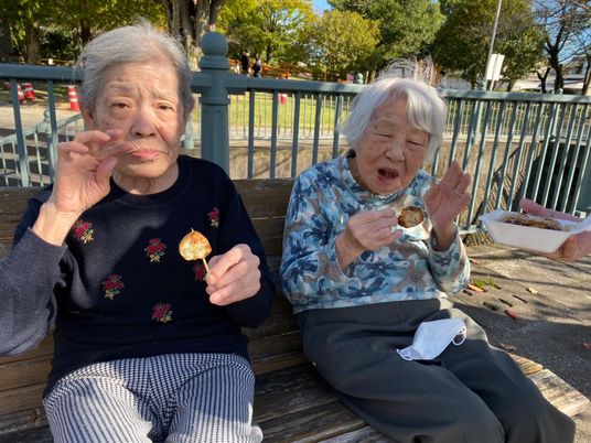 ベンチで食事を楽しむ高齢者二人