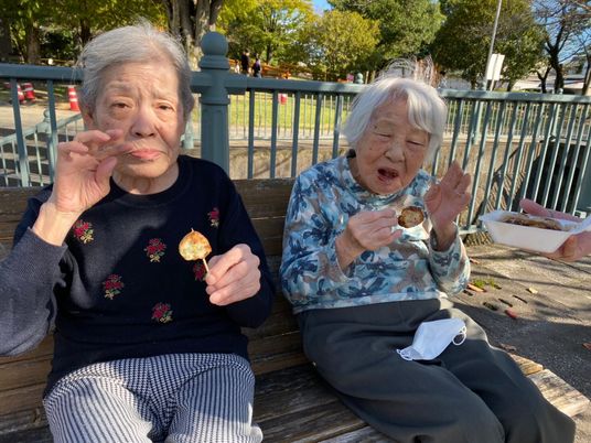 ベンチで食事を楽しむ高齢者二人