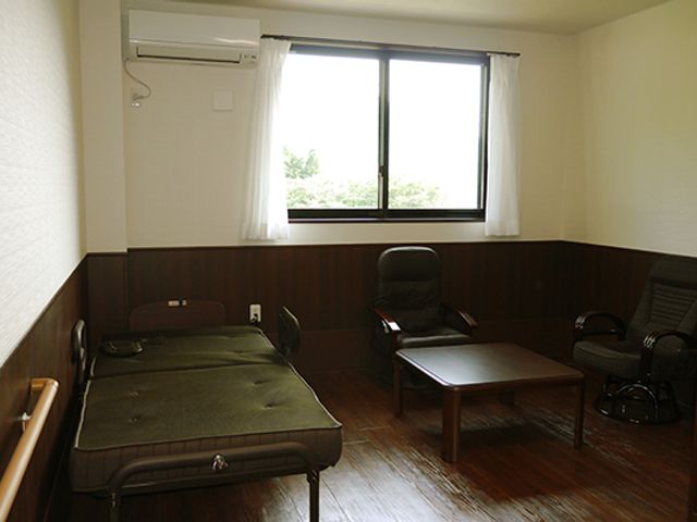 窓際の居室 居室 自然光が差し込む落ち着いた部屋です。リラックスできる家具が配置されています。