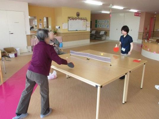 卓球を楽しむ利用者と職員