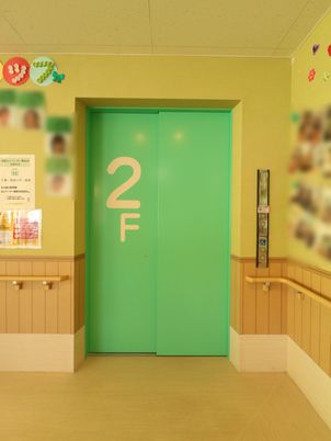 緑のエレベーター扉と掲示物