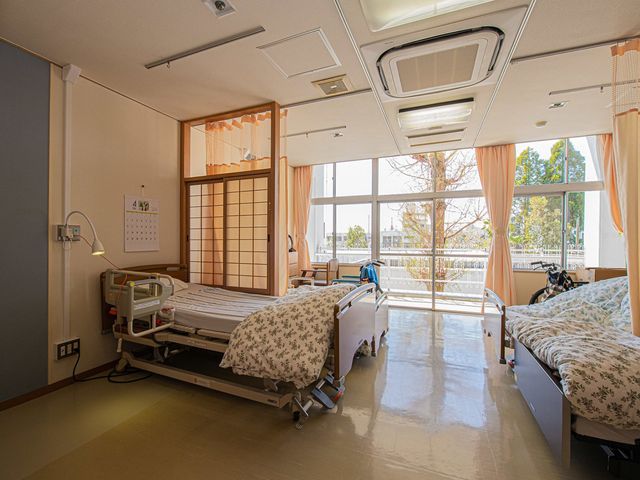自然光の射し込む居室 居室 明るい空間で、ゆったりとしたベッドが配置されています。窓からの自然光で快適です。
