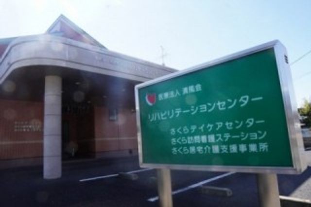 看板前の外観 看板 施設の名前が記載された看板前の風景です。働く環境を知る一助になります。