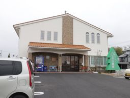 白壁の建物と駐車場外観