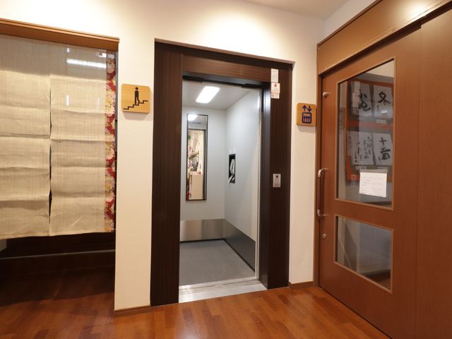 廊下と和室の入口 エレベーター きれいに保たれた廊下には、温かみのある和室が配されています。静かで落ち着いた雰囲気が伝わってきますね。