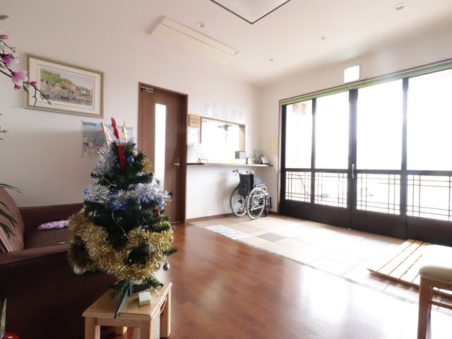 入口付近のクリスマスツリー 玄関 季節の飾り付けがされた快適なエントランスです。通りに面した大きな窓からは自然光が差し込み、明るい雰囲気を演出しています。