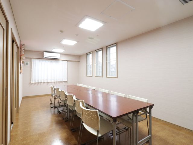 照明が明るい会議室 共有スペース ゆったりした空間の会議室です。広々としたテーブルに向かい合わせで座ることができ、打ち合わせなどに最適です。