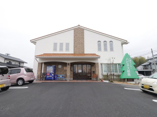 白い壁の建物エントランス 外観 ゆったりとしたエントランスが印象的な快適な空間です。訪れる方々を温かく迎え入れるための工夫が見られます。
