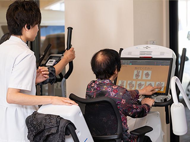 機能訓練室での運動 機能訓練室 スタッフのサポートを受けながら、安全に使用できるトレーニング機器が整っています。明るい空間での運動が可能です。