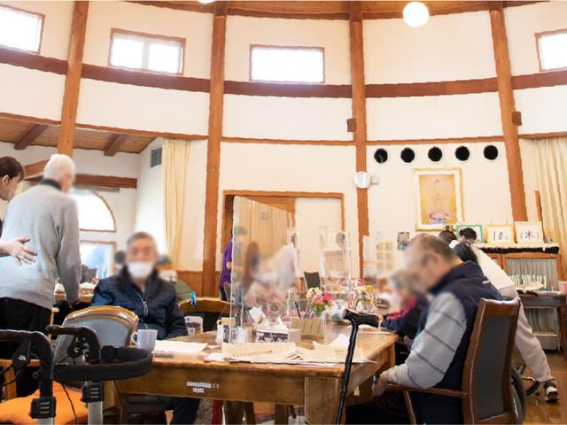 賑やかな室内 ラウンジ 広々としたラウンジで、利用者が自由に談笑しています。自然光が優しく差し込む明るい空間です。