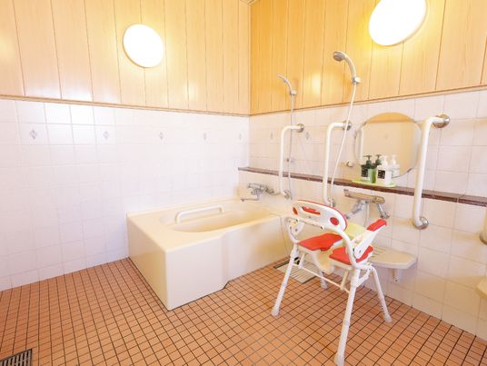施設の写真 オレンジの椅子が置かれた浴室