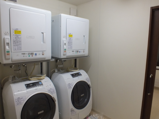 乾燥機と洗濯機のある洗濯室  